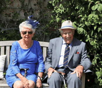 senior couple in fancy clothes sitting on a bench