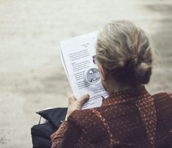 woman reading with magnifying glass