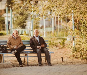 two medicare aged men sitting on a bench