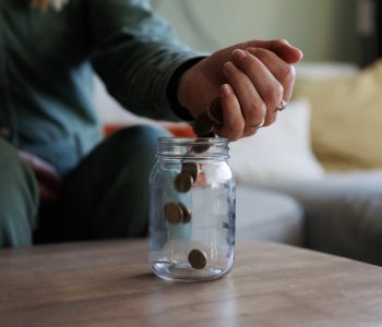 hand dropping coins into a jar