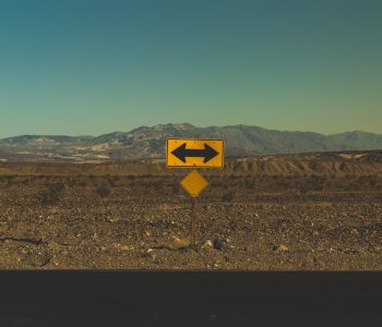 yellow arrow road sign in the desert